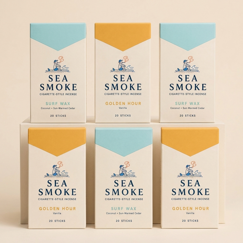 Six Sea Smoke packs on a cream studio backdrop — three Golden Hour, three Surf Wax